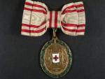 Bronzová čestná medaile Za zásluhy o Červený Kříž s válečnou dekorací na dámské stuze, opravovaný bílý smalt v levé dolní části štítku