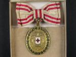 Bronzová čestná medaile Za zásluhy o Červený Kříž s válečnou dekorací na dámské stuze, původní etue